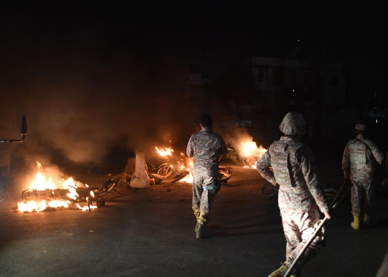 Pakistani Rangers walk past burning motorbikes on a street in Karachi after they were set alight by protestors after the arrest of hardline cleric Khadim Hussain Rizvi. Pakistani police detained a hardline cleric whose party recently paralysed the country with violent protests over the acquittal of a Christian woman accused of blasphemy. AFP