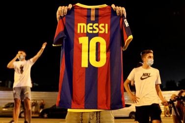 Soccer Football - Camp Nou, Barcelona, Spain - August 25, 2020 A Barcelona fan holds up a Lionel Messi shirt outside the Camp Nou after captain Lionel Messi told Barcelona he wishes to leave the club immediately, a source confirmed on Tuesday REUTERS/Nacho Doce