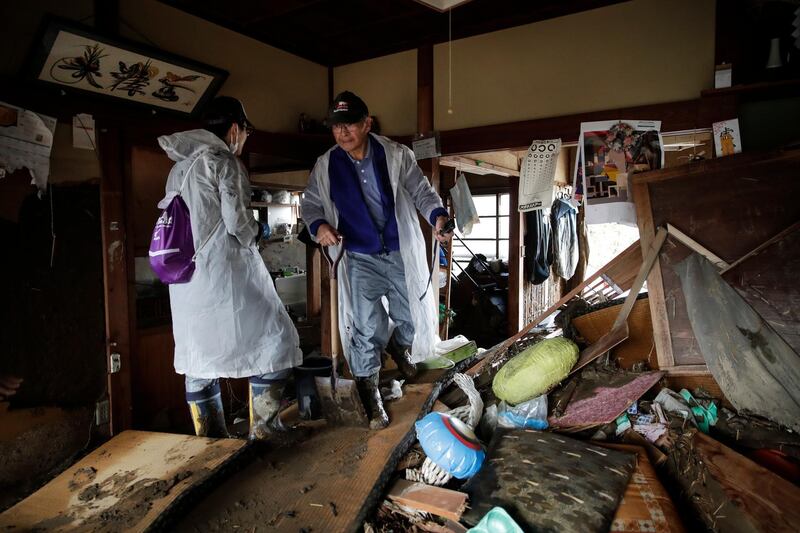 Toshio Yonezawa, 73, center, surveys his home with son, Yusuke, after Typhoon Hagibis passed through his neighborhood, in Nagano, Japan. More victims and more damage have been found in typhoon-hit areas of central and northern Japan, where rescue crews are searching for people still missing. AP Photo