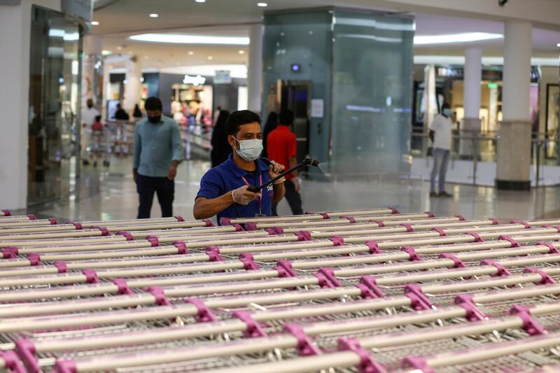 A worker, wearing a face mask, sterilizes shopping carts at a supermarket in Riyadh. Reuters