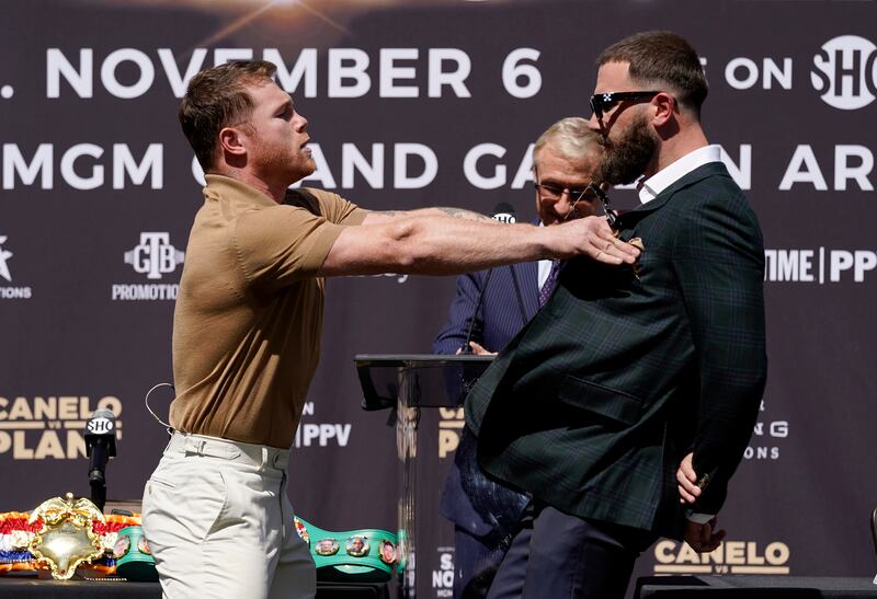 Unified WBC/WBO/WBA super middleweight champion Canelo Alvarez, left, shoves undefeated IBF super middleweight champion Caleb Plant during a news conference to announce their 168-pound title bout.  The fight is scheduled for Saturday, November  6 in Las Vegas. AP