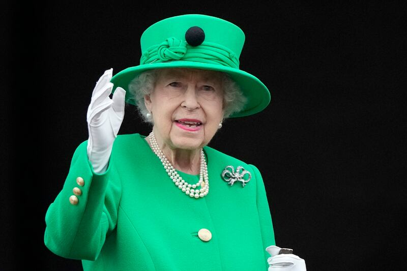 Queen Elizabeth II wears a green coat and hat to surprise crowds with a Buckingham Palace balcony appearance on June 5. AP