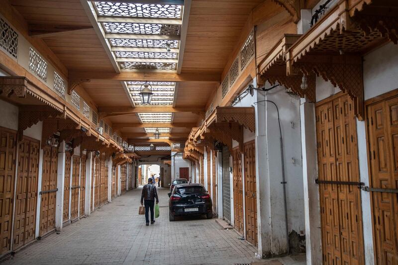 A man walks past closed shops before the start of the holy month of Ramadan in the usually bustling Medina of Rabat, during a health state of emergency and home confinement orders, in Rabat, Morocco, Thursday, April 23, 2020. The new coronavirus causes mild or moderate symptoms for most people, but for some, especially older adults and people with existing health problems, it can cause more severe illness or death. (AP Photo/Mosa'ab Elshamy)