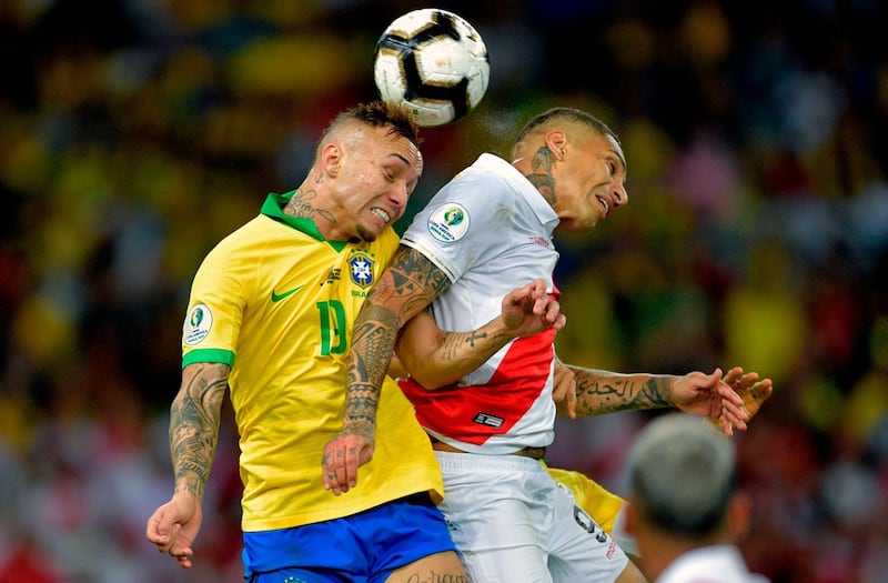 Peru's Paolo Guerrero and Brazil's Everton enjoy an aerial duel. AFP
