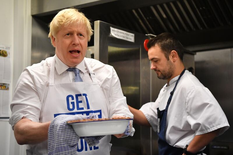 Britain's Prime Minister Boris Johnson prepares a pie at the Red Olive kitchen in Derby, central England on December 11, 2019 while on the campaign trail. Britain will go to the polls tomorrow to vote in a pre-Christmas general election. / AFP / POOL / Ben STANSALL
