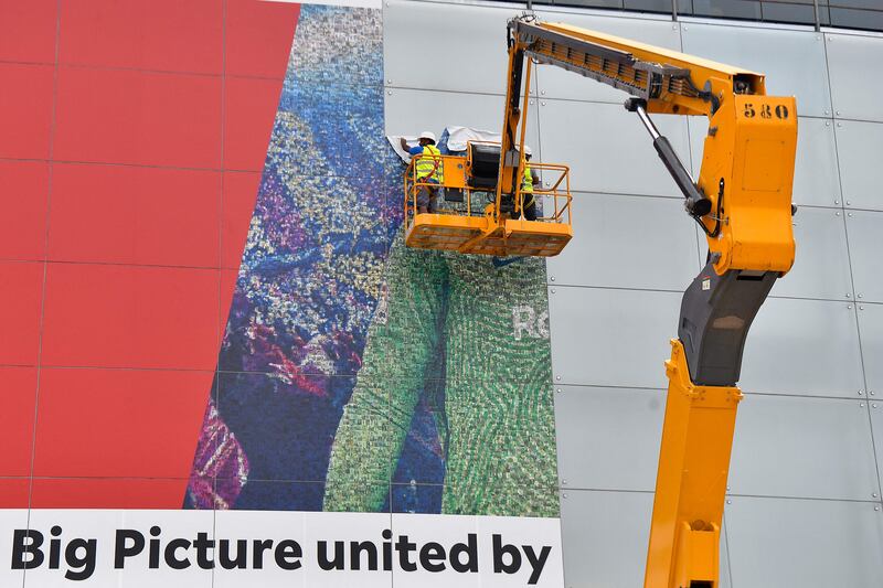 Workers remove a poster featuring Barcelona's departing Argentinian forward Lionel Messi from Camp Nou.