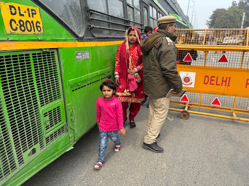 Commuters walk after police barricaded a motorway at Singhu near New Delhi. AP
