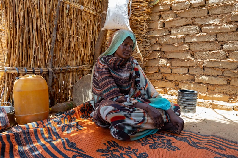 Thirty-three-year-old Sudanese refugee Maka Abdulrhaman sits in front of the shelter she built in the Farchana refugee camp