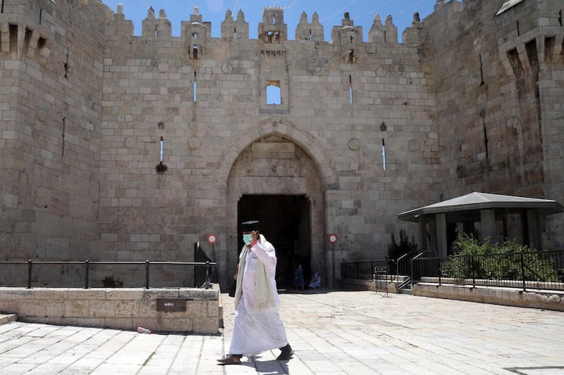A man walks past the Damascus Gate as it sits empty near the Dome of the Rock and al-Aqsa mosque compound, which remains shut to prevent the spread of coronavirus in Jerusalem's Old City. AP Photo