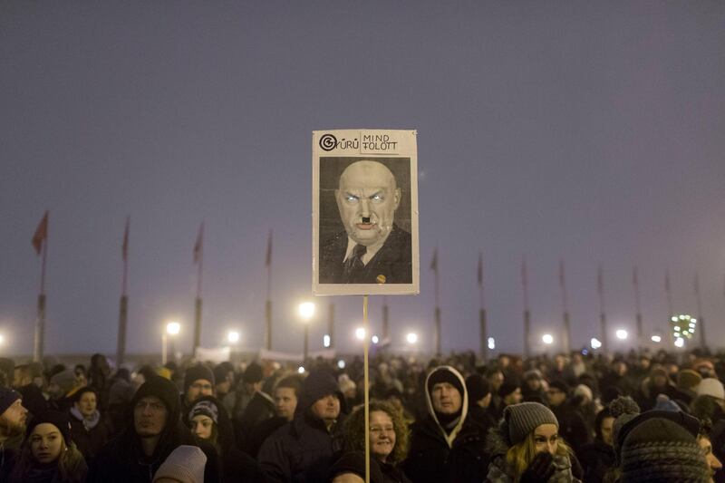 A poster mocking Hungary's Prime Minister Victor Orban is seen during an anti-government march in central Budapest, Hungary, Friday, Dec. 21, 2018. Thousands of people marched in anti-government protests Friday in Budapest, upset over labor law changes, increasing corruption and limits on academic freedom under Prime Minister Orban's nationalist government. (AP Photo/Marko Drobnjakovic)