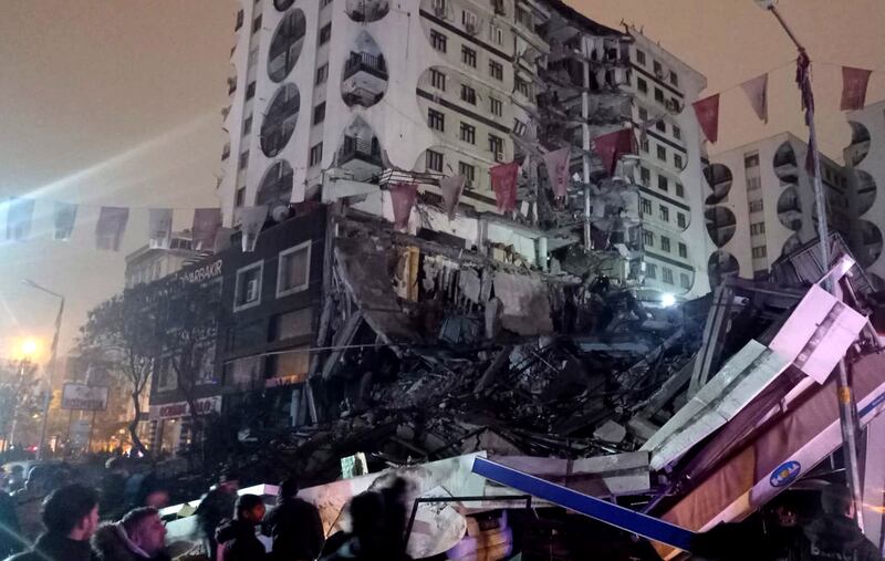 People at the site of a collapsed building. EPA