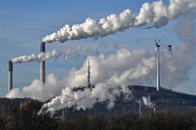 A Uniper coal-fired power plant and a BP refinery steam beside a wind generator in Gelsenkirchen, Germany. AP