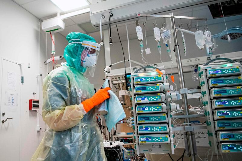 A nurse wearing protective clothing and face mask takes care of a COVID-19 patient at the Extracorporeal Membrane Oxygenation (ECMO) department in the Karolinska hospital in Solna, near Stockholm, Sweden, on April 19, 2020 during the coronavirus COVID-19 pandemic. / AFP / Jonathan NACKSTRAND
