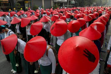 School teachers in their uniform and traditional Burmese hats participate in a demonstration against the coup in Mandalay. AP Photo