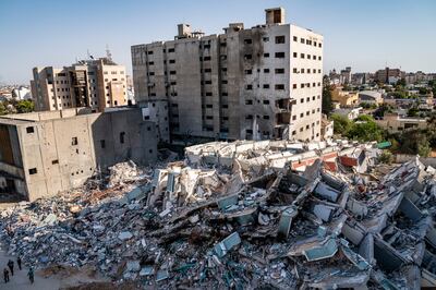 People walk past the rubble of the 12-storey al-Jalaa building in Gaza city that housed the Associated Press bureau in Gaza City that was destroyed in an Israeli air-strike in the 11-day war between Gaza's Hamas rulers and Israel.  AP