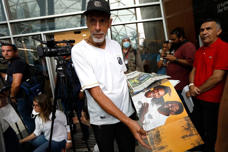 A Santos fan holds a magazine with the picture of Pele outside Hospital Israelita where the late football legend passed away on December 29, 2022 in Sao Paulo, Brazil. Getty