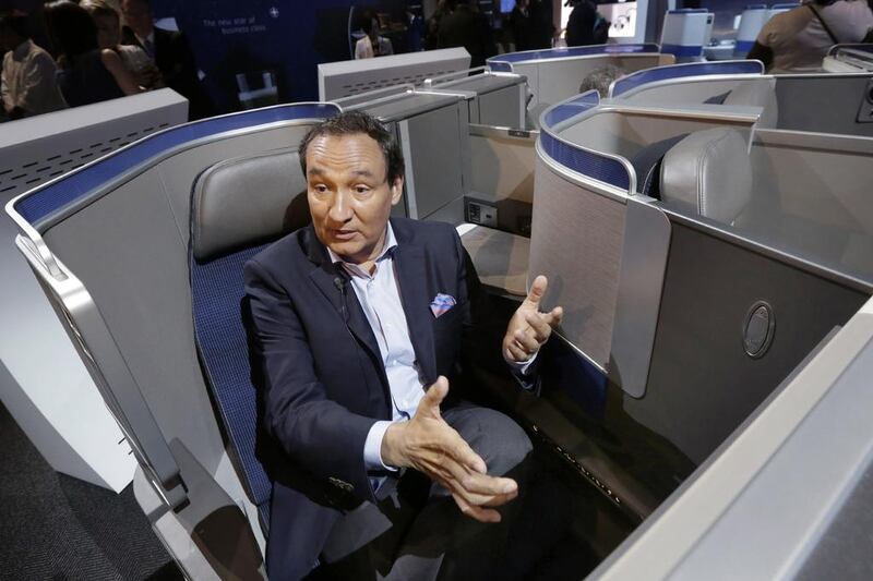 United Airlines CEO Oscar Munoz speaks during an interview in New York, while seated in the seating configuration of the carrier's new Polaris service. United Airlines says it will raise the limit to $10,000 on payments to customers who give up seats on oversold flights. Richard Drew / AP Photo