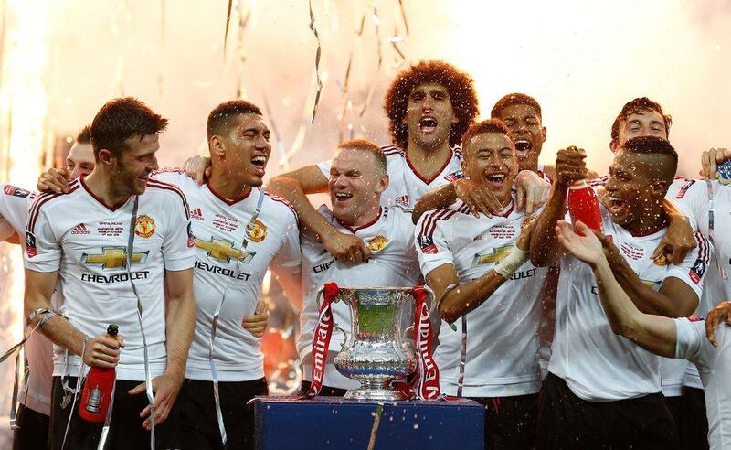 Manchester United’s players celebrate with the trophy after their victory after extra time in the English FA Cup final football match between Crystal Palace and Manchester United at Wembley stadium in London on May 21, 2016. Manchester United won the game 2-1, after extra time. Ian Kington / AFP