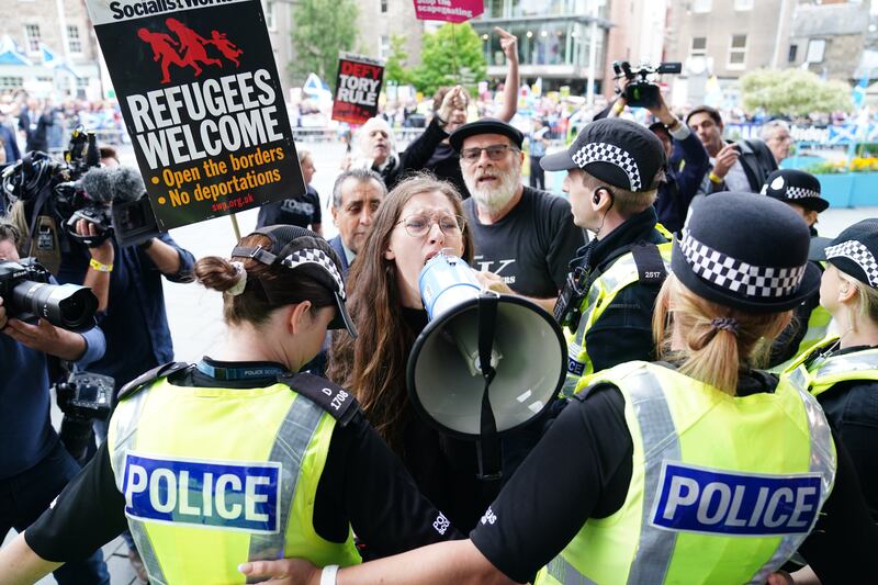 Police hold back protesters outside Perth Concert Hall, Scotland, where Conservative leadership candidates Liz Truss and Rishi Sunak were speaking. PA