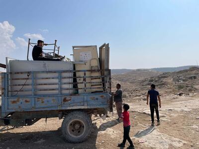 Villagers fleeing settler violence prepare to move with their belongings, some donated by European states, from the village of Khirbet Zanuta. The National