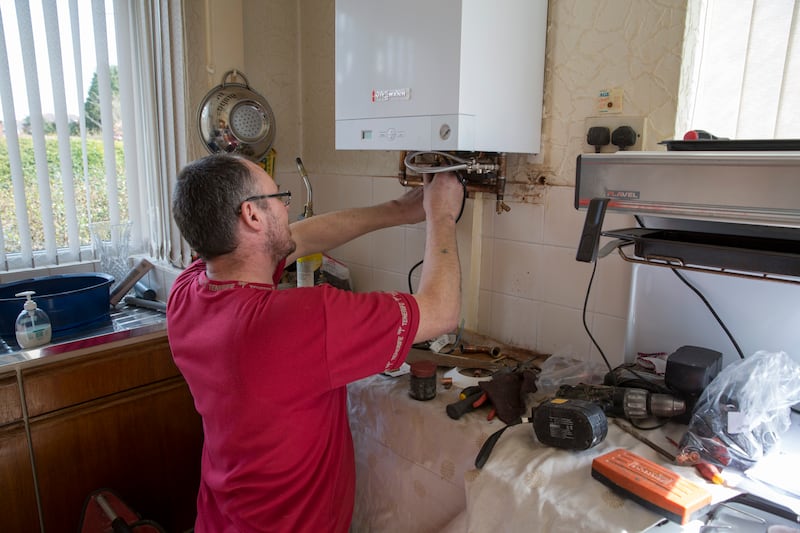 A plumber installs a new fuel-efficient boiler in a UK home. Getty mages