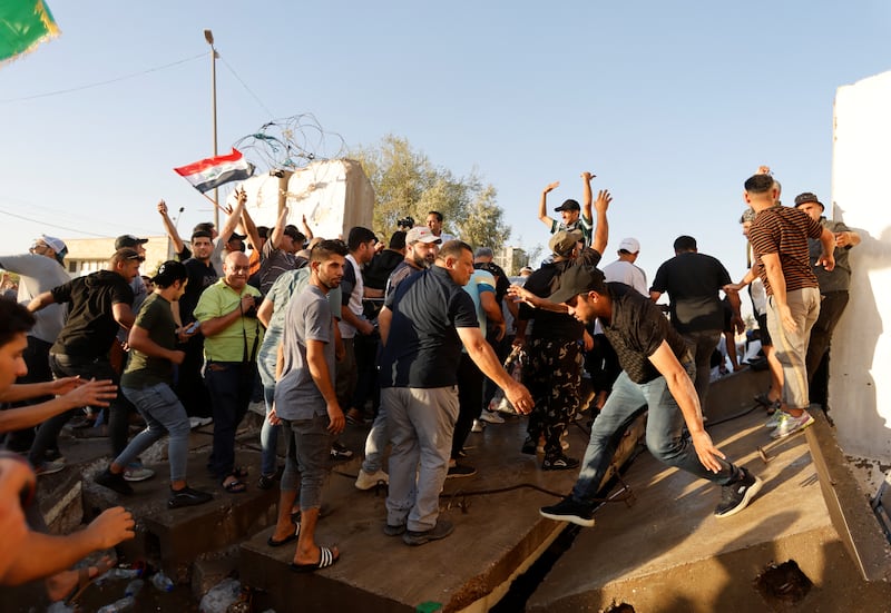 Protesters break down barricades in Baghdad. Reuters