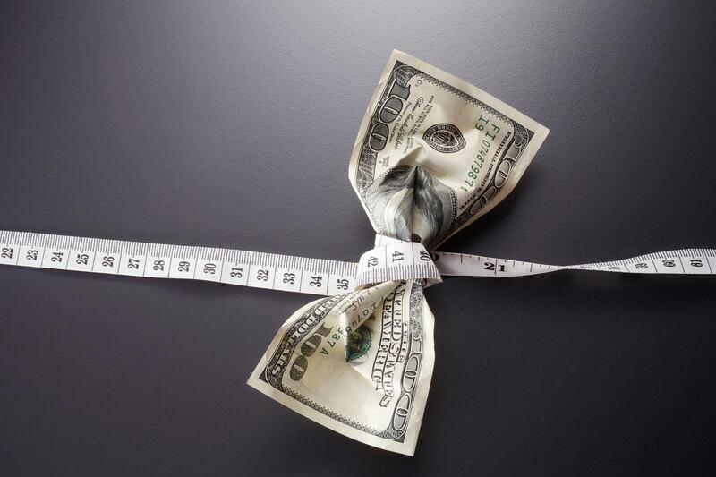 close up of the us currency and tape measure