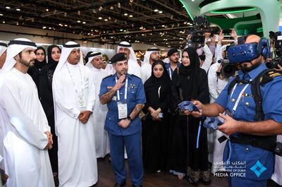 The Crown Prince looks on as a customs officer tried out the latest in VR technology. Courtesy: Dubai Media Office