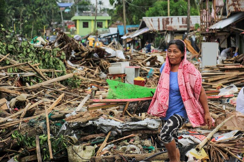 A resident walks past debris from destroyed houses after Typhoon Kammuri hit the city of Sorsogon, south of of Manila. AFP