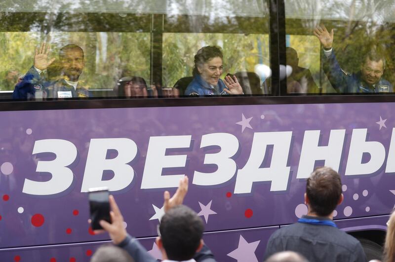 Hazza Al Mansouri, Oleg Skripochka and Jessica Meir wave to crowds as they leave for the launch pad. EPA