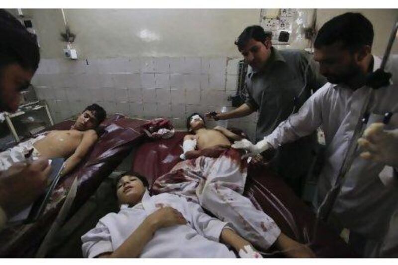 Family members and hospital staff tend to injured students after they were brought to the Lady Reading Hospital in Peshawar after gunmen opened fire on a school bus. Fayaz Aziz / Reuters