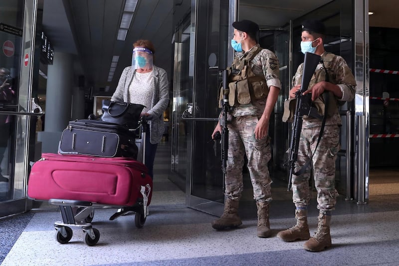 Lebanese soldiers stand guard as a woman leaves the Rafik Hariri International Airport in Beirut. AP