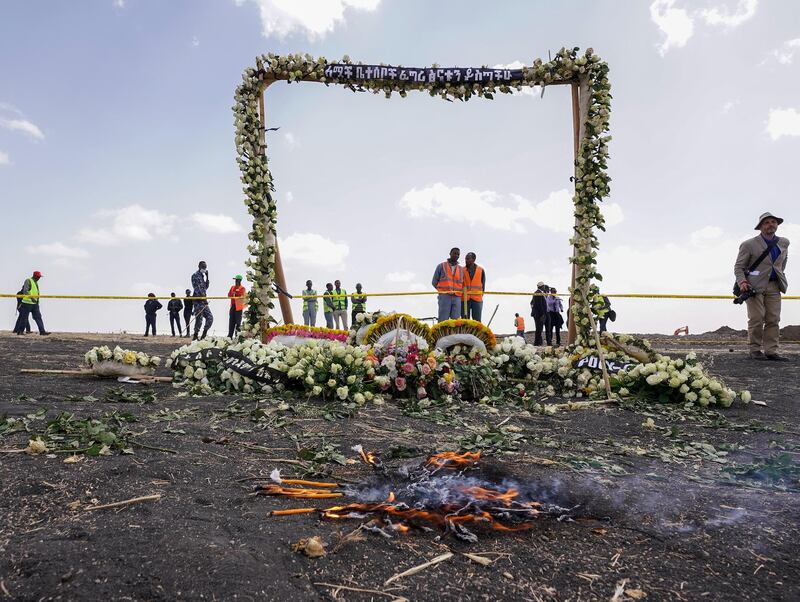 Candles burn before a flower-adorned memorial arch erected at the site of the Ethiopian Airlines Flight ET302 crash in Ejere, Ethiopia. Getty Images