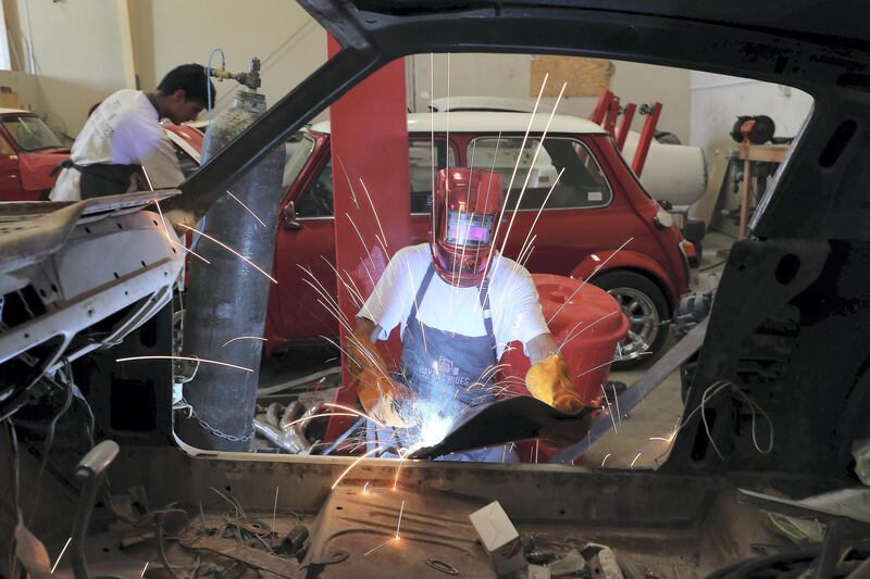 SHARJAH , UNITED ARAB EMIRATES ,  October 29 , 2018 :-  Workers working at the Rayans Rides car workshop at Emirates Industrial City in Sharjah. ( Pawan Singh / The National )  For Motoring. Story by Adam