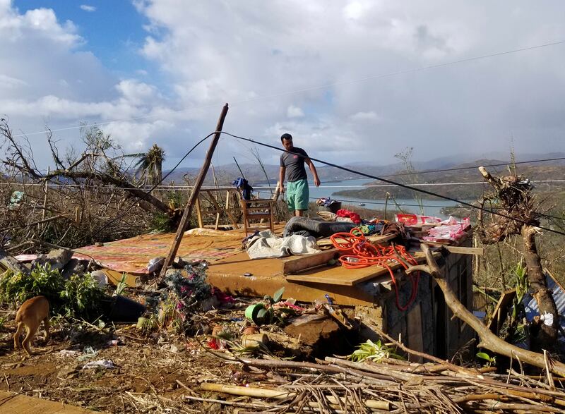 A man checks his damaged home on the Dinagat Islands in the Philippines. AP