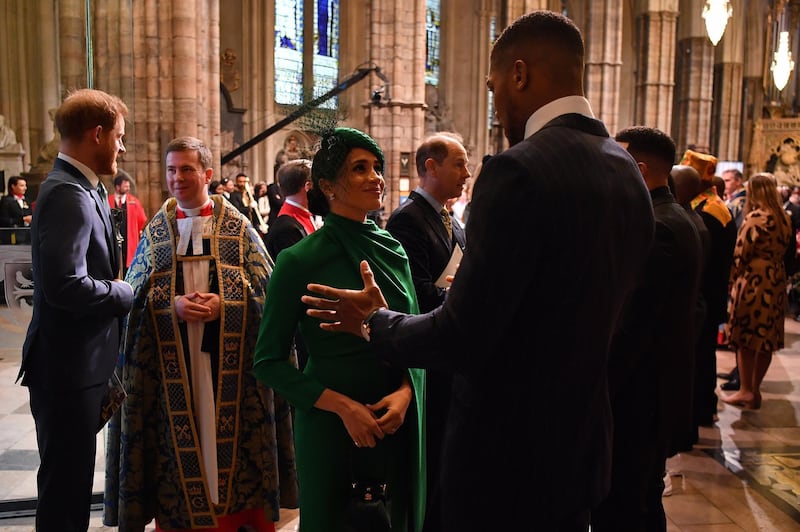 Meghan, Duchess of Sussex talks with British boxer Anthony Joshua as she leaves after attending the Commonwealth Day Service. Getty Images