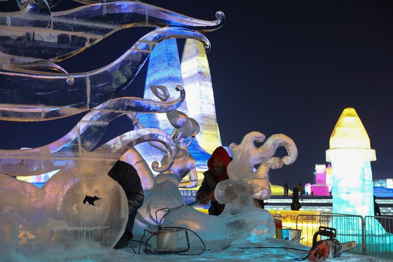 Chinese workers makes an ice sculpture during the Harbin Ice and snow world in Harbin, Heilongjiang Province, China. Getty Images