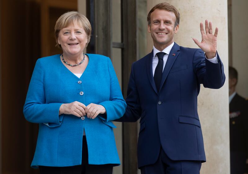 French President Emmanuel Macron welcomes German Chancellor Angela Merkel to the Elysee Palace in Paris on Thursday. EPA