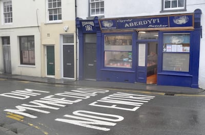 Aberdovey's butcher with Welsh road sign. James Langton for The National