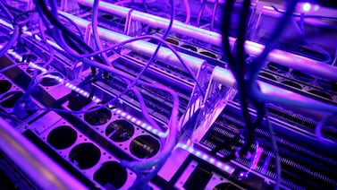 Cryptocurrency miners are seen in a liquid immersion cooling mining tank at the TMG Core stand during the Bitcoin Conference 2022 in Florida. Reuters