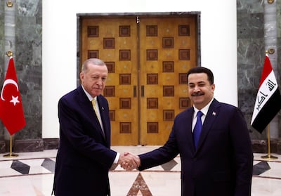 Turkish President Recep Tayyip Erdogan, left, and Iraqi Prime Minister Mohammed Shia Al Sudani shake hands in Baghdad, Iraq. AP