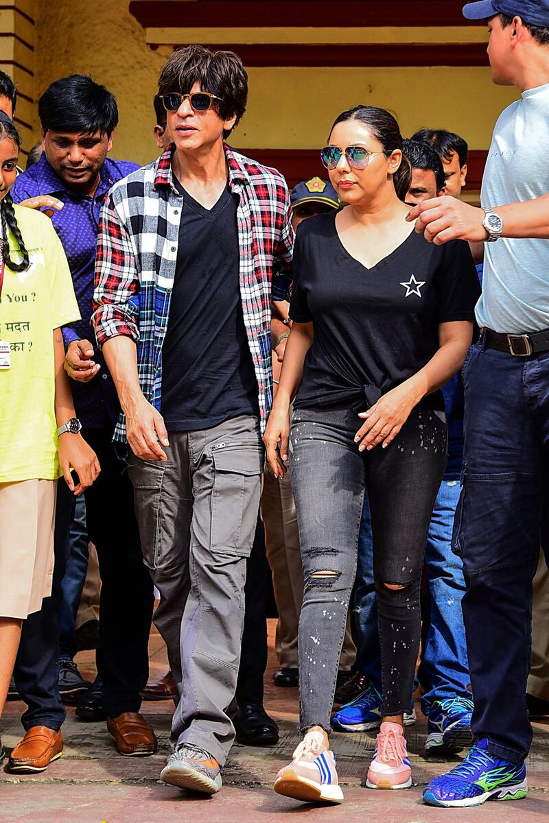 Bollywood actor Shah Rukh Khan (L) and his wife and film producer Gauri Khan (R) leave after casting their votes at a polling station during the state assembly election in Mumbai on October 21, 2019.  / AFP / Sujit Jaiswal
