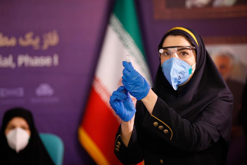An Iranian health worker prepares a dose of locally made COVID-19 vaccine during phase one of its trial test in Tehran, Iran, 29 December 2020. Media reports state that Iran inaugurated and tested its local made coronavirus disease vaccine during the first phase of trial session.  EPA