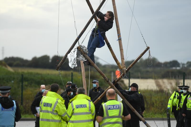 An environmental activist hangs from a bamboo structure at a protest calling for an end to infrastructure work for the proposed HS2 route in October 2020 in Denham. Getty Images
