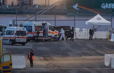 Ambulances and medics arrive at the port of Genoa to assist with the evacuation of 45 Covid-positive passengers. EPA