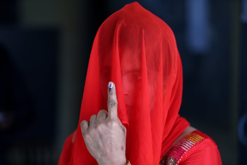 An Indian voter shows her ink-marked finger after casting her ballot at a polling station in Uttar Pradesh. EPA