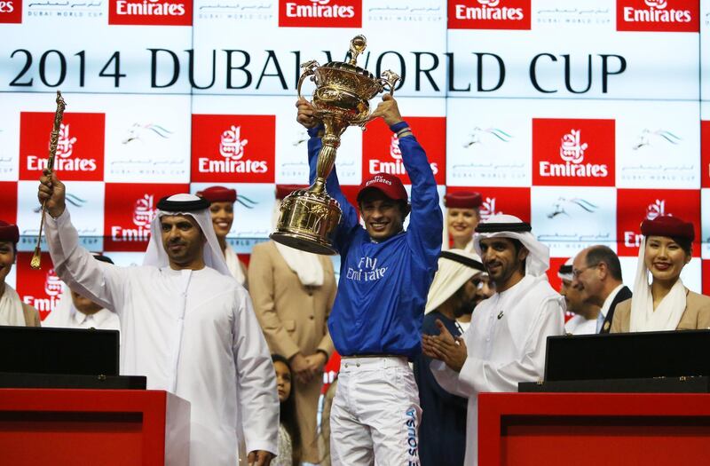 DUBAI , UNITED ARAB EMIRATES Ð Mar 29 , 2014 : Silvestre De Sousa lifts the world cup trophy after wining the Dubai World Cup 9th horse race ( 2000m All Weather ) at the Meydan Racecourse in Dubai. ( Pawan Singh / The National ) For Sports. Story by Jonathan Raymond