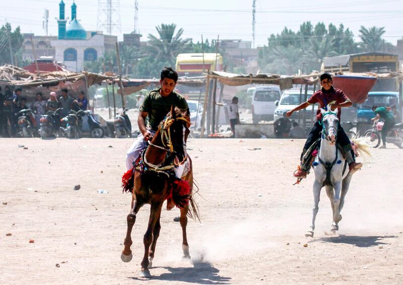Iraqi boys ride horses on the third day of the Eid el-Adha holiday at a park in the central holy shrine city of Najaf. AFP