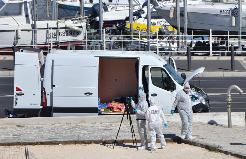 French forensic police officers take images as they search a vehicle following a car crash in the southern Mediterranean city of Marseille. Bertrand Langlois / AFP