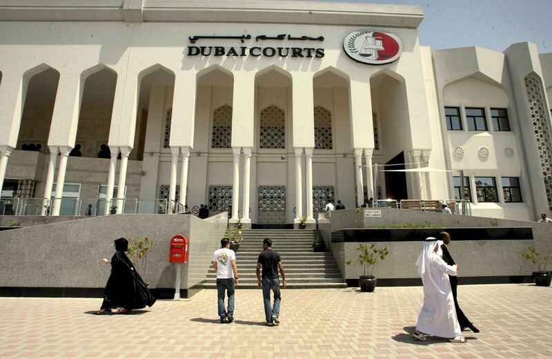 Pedestrians walk past Dubai's courts building during a hearing on April 04, 2010 in the case of a British couple sentenced to a month in jail after being convicted of kissing in public in a restaurant in the Muslim Gulf emirate. The couple's lawyer said the appeals court upheld the one-month prison sentence against the two, named by the British press as Ayman Najafi, 24, a British expat, and tourist Charlotte Lewis, 25. The couple were arrested in November 2009, after they were accused of consuming alcohol and kissing in a restaurant in the trendy Jumeirah Beach Residence neighbourhood.     AFP PHOTO/STR (Photo by AFP)